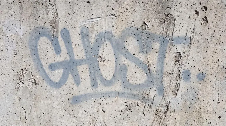 Graffiti Geisterbild - Misslungener DIY-Entfernungsversuch mit sichtbaren Rückständen auf Betonfläche Graffiti Geisterbild - Misslungener DIY-Entfernungsversuch mit sichtbaren Rückständen auf Betonfläche