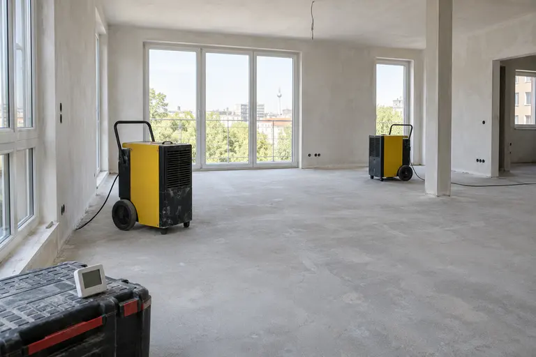 Bautrockner in einem noch nicht ausgebauten Raum mit frischem Estrich